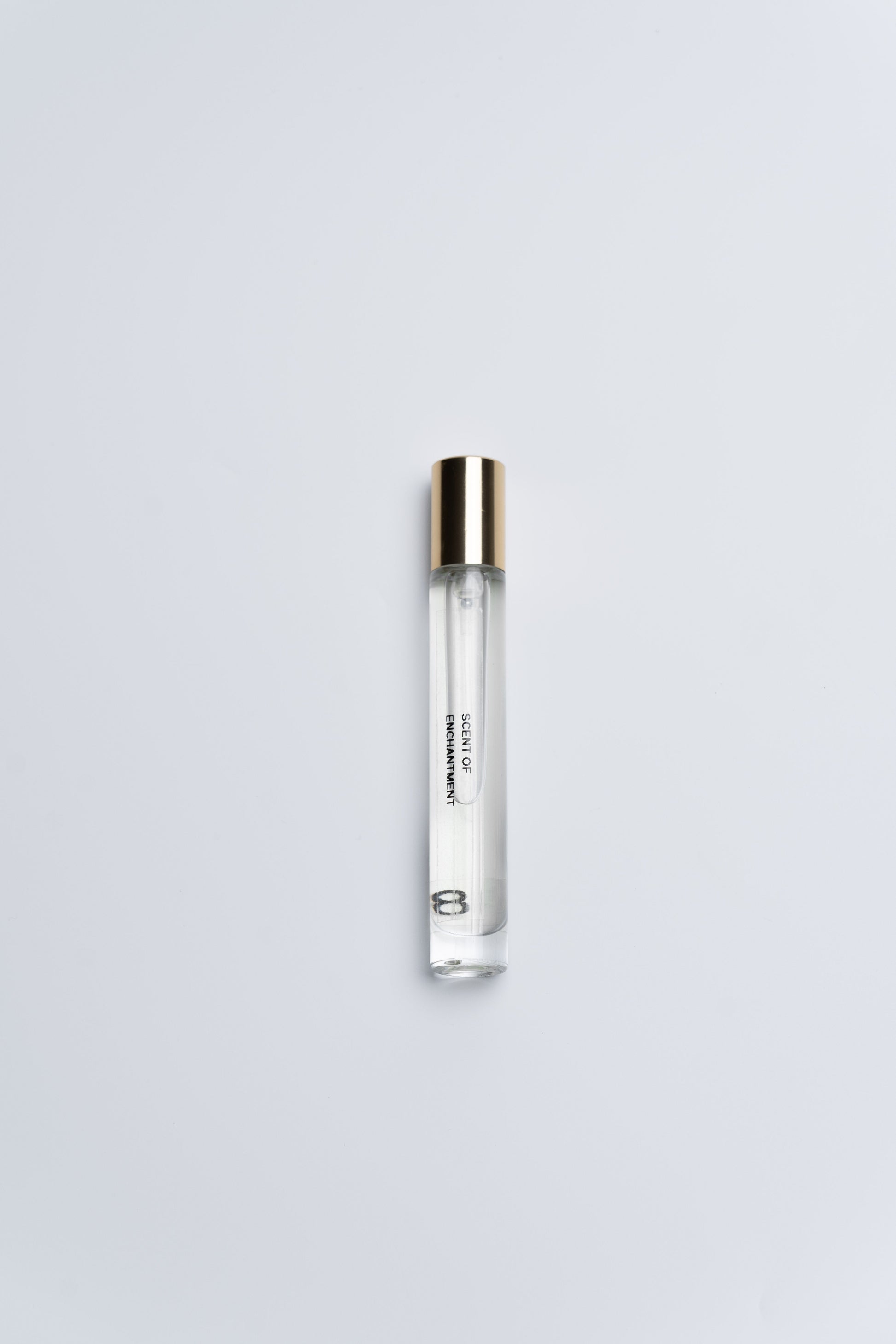 Clear cylindrical container with gold cap on a light gray background