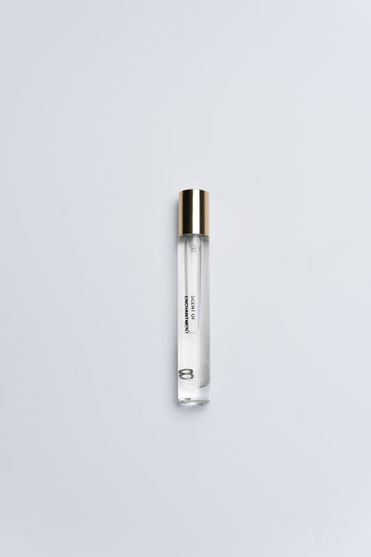 Clear cylindrical container with gold cap on a light gray background